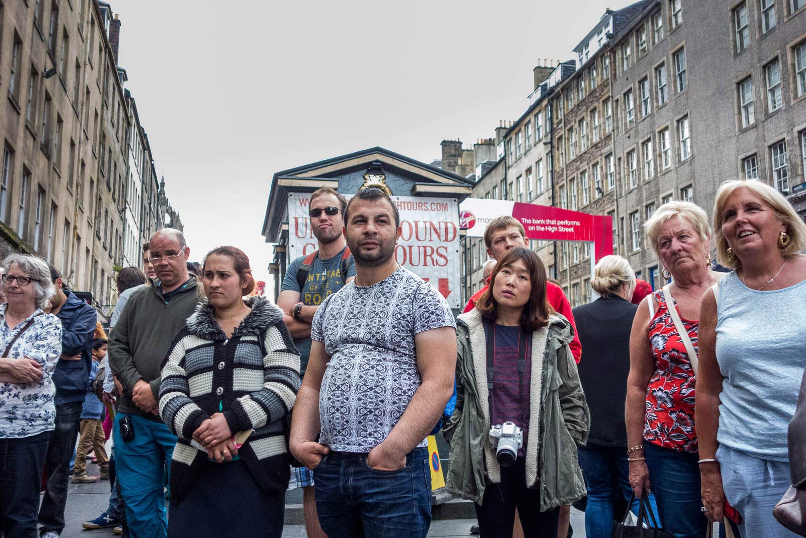 A group of people watching a street perfomance on the Royal Mile during the Edinburgh Festival