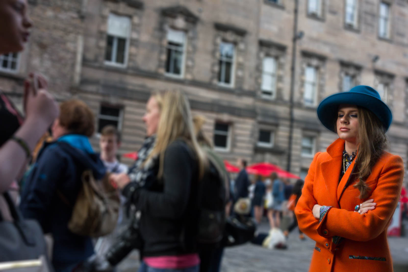 A girl in orange and blue walks up the Royal Mile during the Edinburh Festival